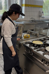 Schülerin bereitet beim Girls’ Day am Herd in der Küche der Albertinen Services in Hamburg-Volksdorf einen Pfannkuchen zu.
