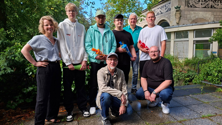 Gruppenbild der neuen Auszubildenden bei Werkstück mit Geschäftsführer und Mitarbeitenden auf der Terrasse der Wannse-Villa Gruppenbild der neuen Auszubildenden bei Werkstück mit Geschäftsführer und Mitarbeitenden auf der Terrasse der Wannse-Villa